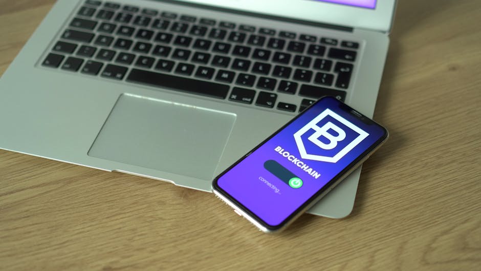 Smartphone prikazuje blockchain aplikaciju na laptopu